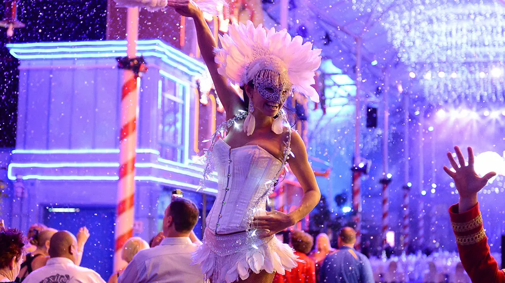 A nighttime scene of the Corporate Christmas event at Warner Bros. Movie World, with festive decorations, colourful lights, and a joyful atmosphere