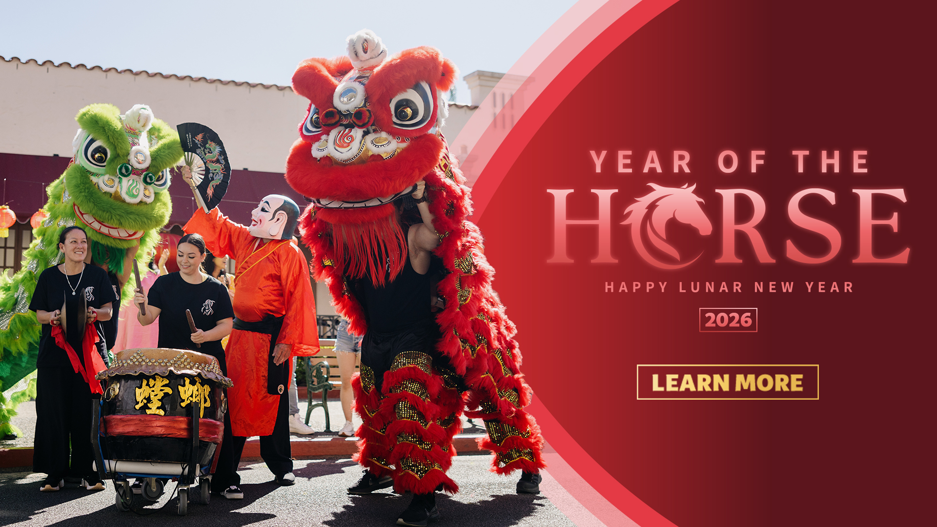 People in traditional attire perform a colorful lion dance with red and green costumes to celebrate Lunar New Year. Text reads "Year of the Horse 2026, Happy Lunar New Year," with a button saying "Learn More.