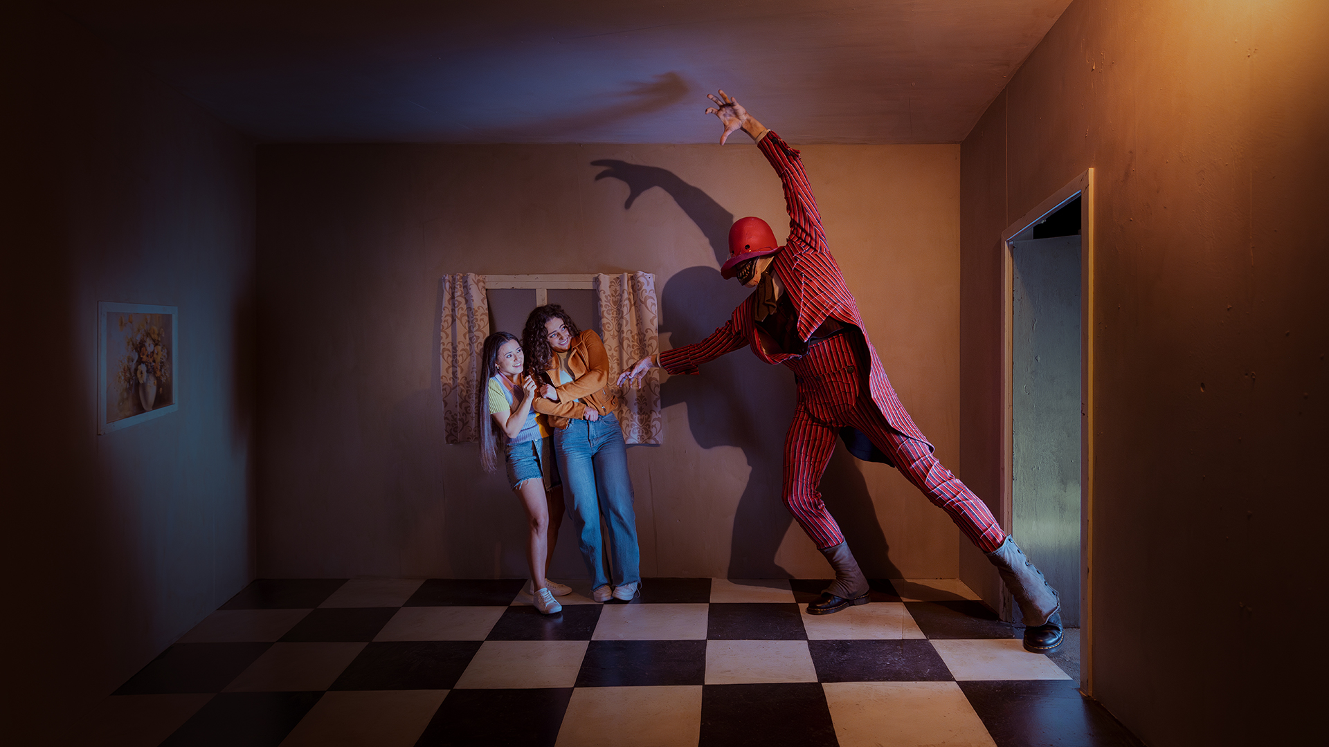 Two frightened women stand in a small, dimly lit room as a tall figure in a red striped suit and hat looms menacingly, casting a dramatic shadow on the wall. The floor has a black-and-white checkered pattern.