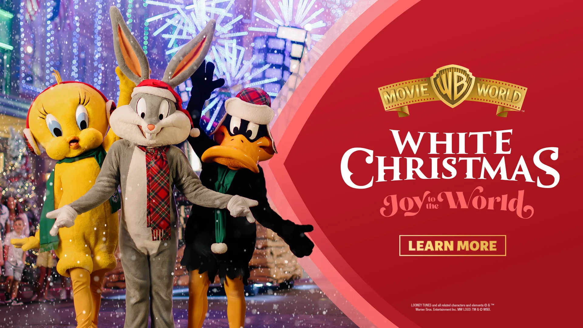 Tweety, Bugs Bunny, and Daffy Duck wear Christmas scarves and hats, standing together in a festive, snowy theme park with bright lights. Text reads "White Christmas: Joy to the World, Movie World, Village Roadshow Theme Parks.