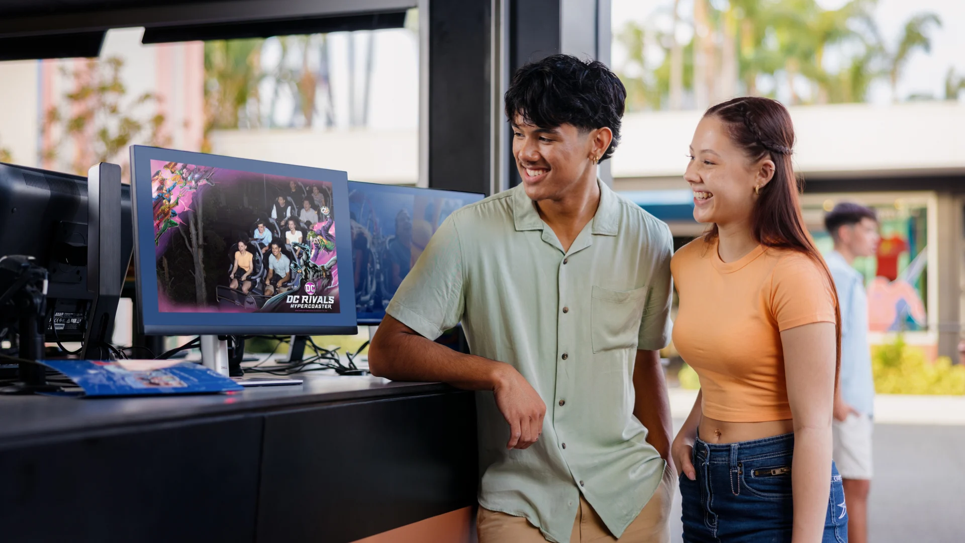 A person pointing excitedly to their photo on the DC Rivals HyperCoaster at the Ride Photo Booth at Warner Bros. Movie World, capturing a thrilling and memorable moment from the ride