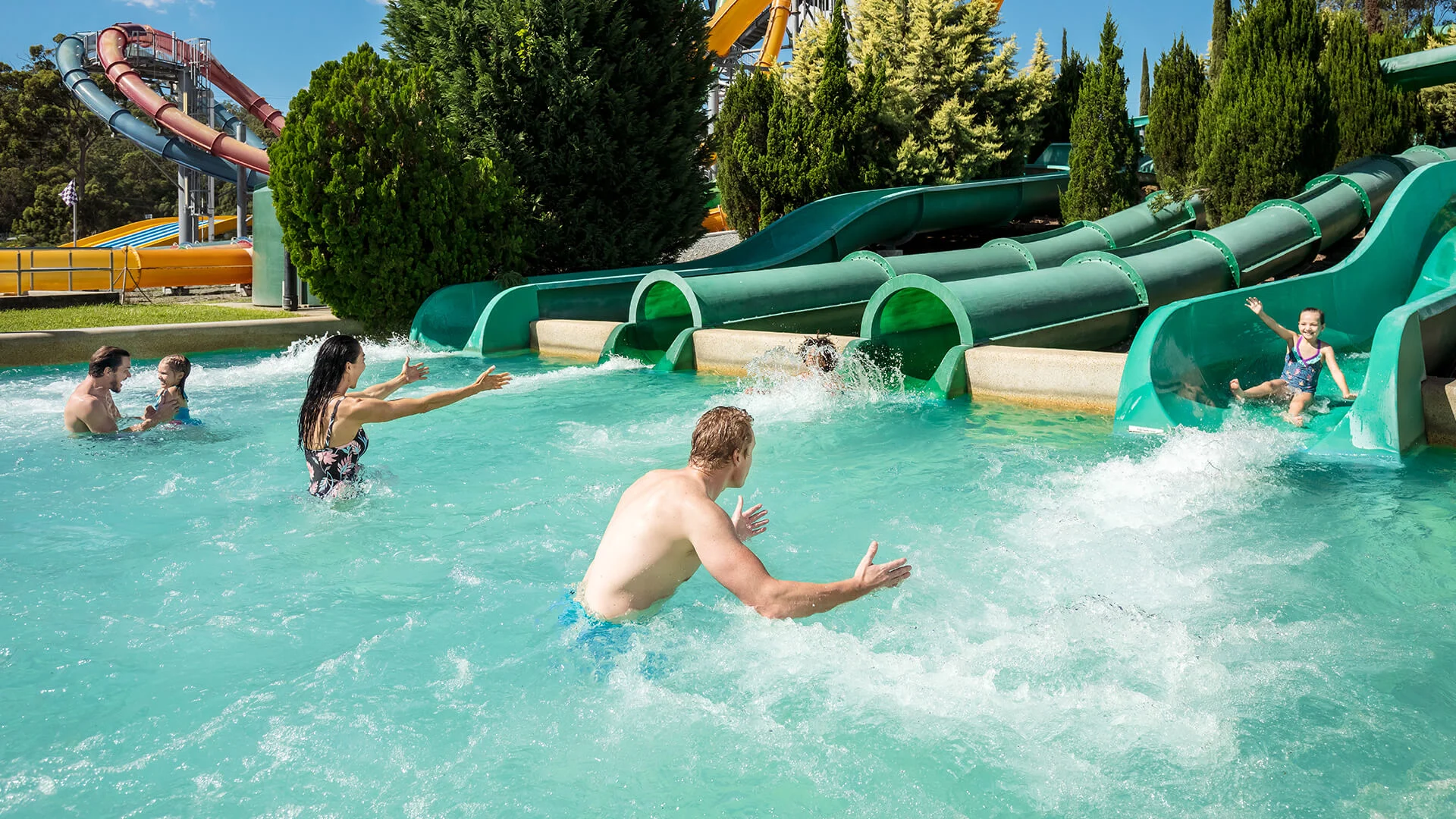 Kids coming down the slide with parents awaiting in the below splashdown pool
