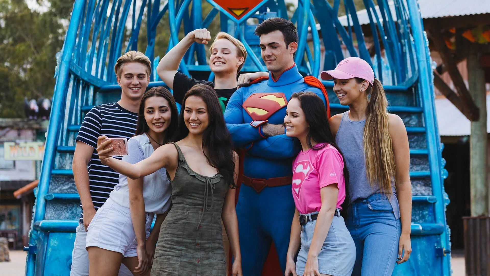 A group of people taking a selfie with Superman in front of the Superman float at Warner Bros. Movie World, capturing a fun and memorable moment with the superhero