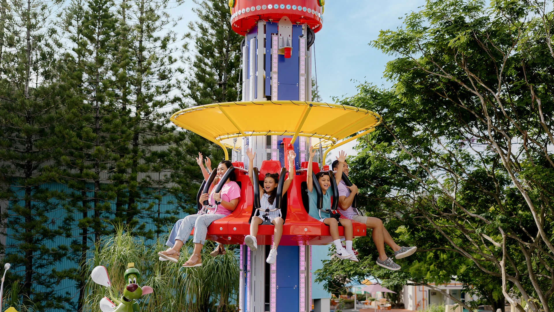 A family having a blast on the Marvin the Martian: Cosmic Boom family ride at Warner Bros. Movie World, experiencing cosmic adventures and excitement