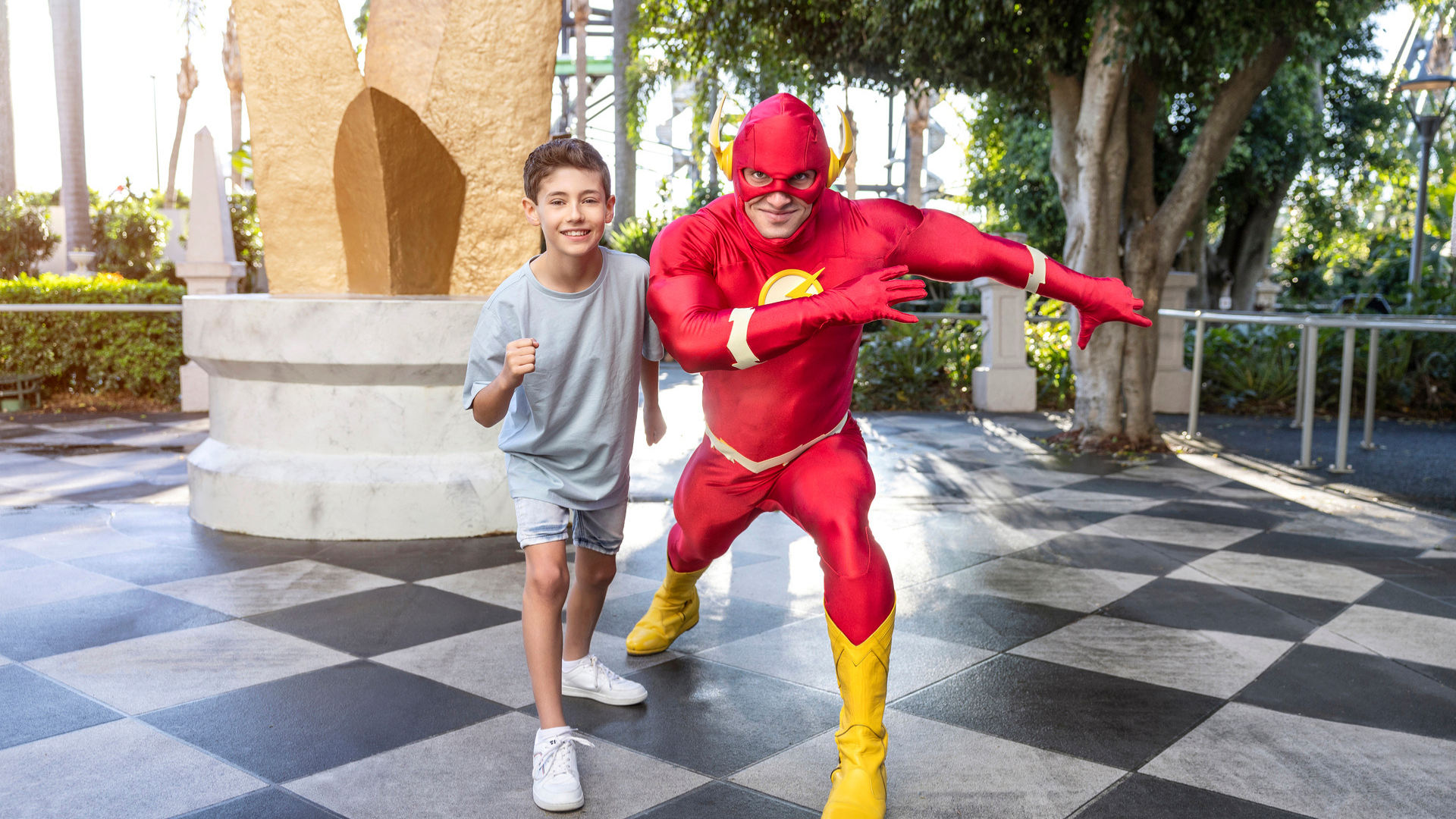 The Flash posing with a mother and her son at Warner Bros. Movie World