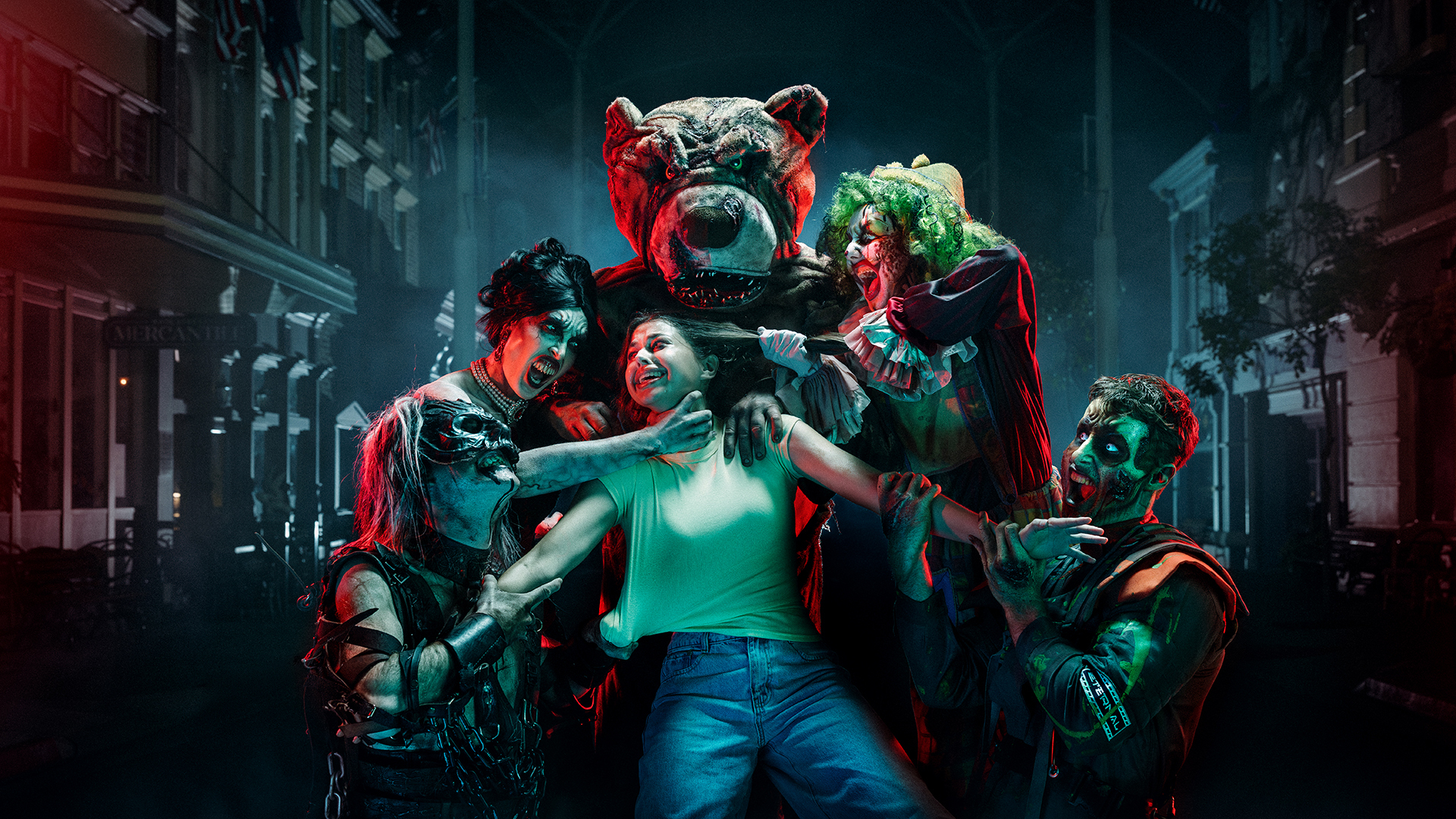 A person in a green tank top is surrounded by people in spooky costumes and face paint, including a bear mascot and clowns, on a dimly lit street at night, creating a tense, eerie atmosphere.