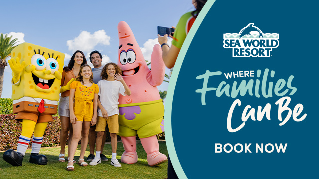 A family poses with SpongeBob SquarePants and Patrick Star mascots at Sea World Resort beside a sign reading "Where Families Can Be. Book Now.