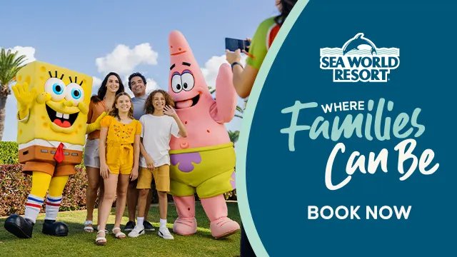 A family poses with SpongeBob SquarePants and Patrick Star mascots at Sea World Resort beside a sign reading "Where Families Can Be. Book Now.
