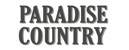 The image displays the words "PARADISE COUNTRY" in bold, uppercase, serif font with a white outline.