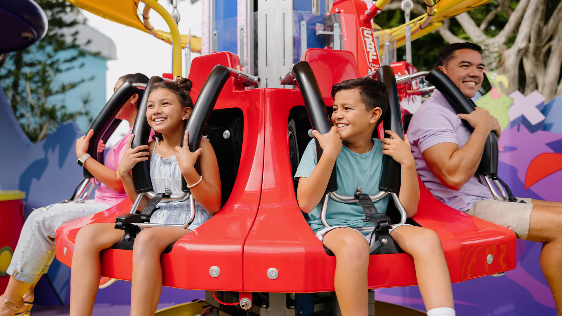 A close-up of a happy family enjoying the Marvin the Martian: Cosmic Boom family ride at Warner Bros. Movie World, experiencing cosmic adventures and excitement together