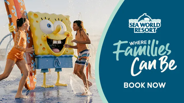 Two children play in water with a person in a SpongeBob SquarePants costume at Sea World Resort, alongside a banner reading "Where Families Can Be. Book Now.