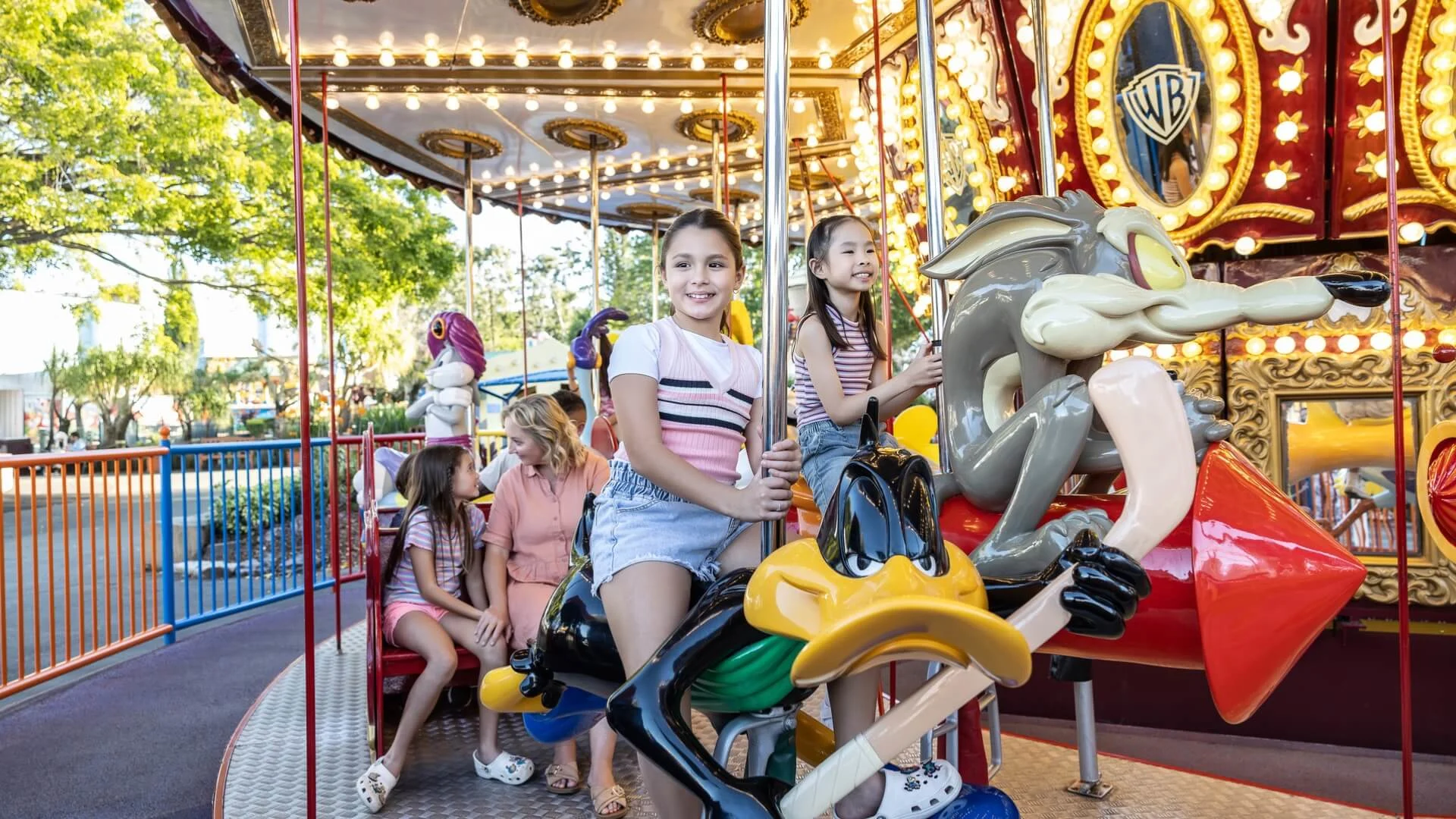 Happy children with bright smiles enjoying the Looney Tunes Carousel at Warner Bros. Movie World
