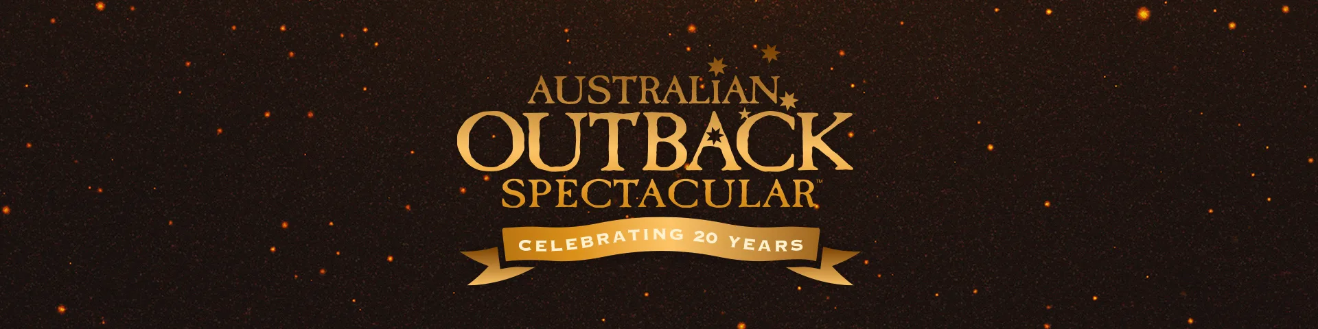 Gold text reads "Australian Outback Spectacular" with three stars, and a gold ribbon below says "Celebrating 20 Years" on a dark background with orange sparkles.