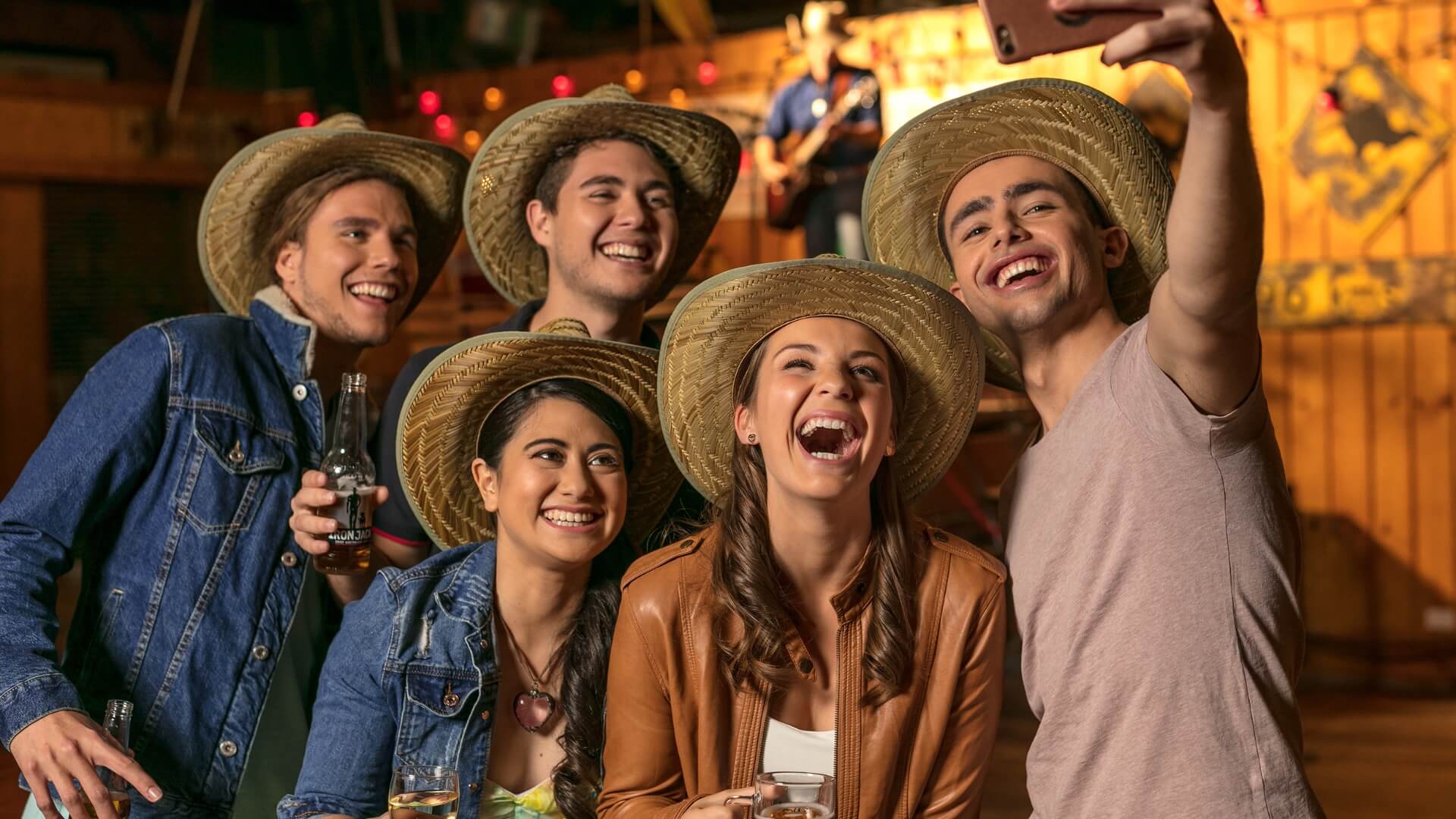 Group of friends in cowboy hats laughing and taking a selfie during the pre-show entertainment at Australian Outback Spectacular.