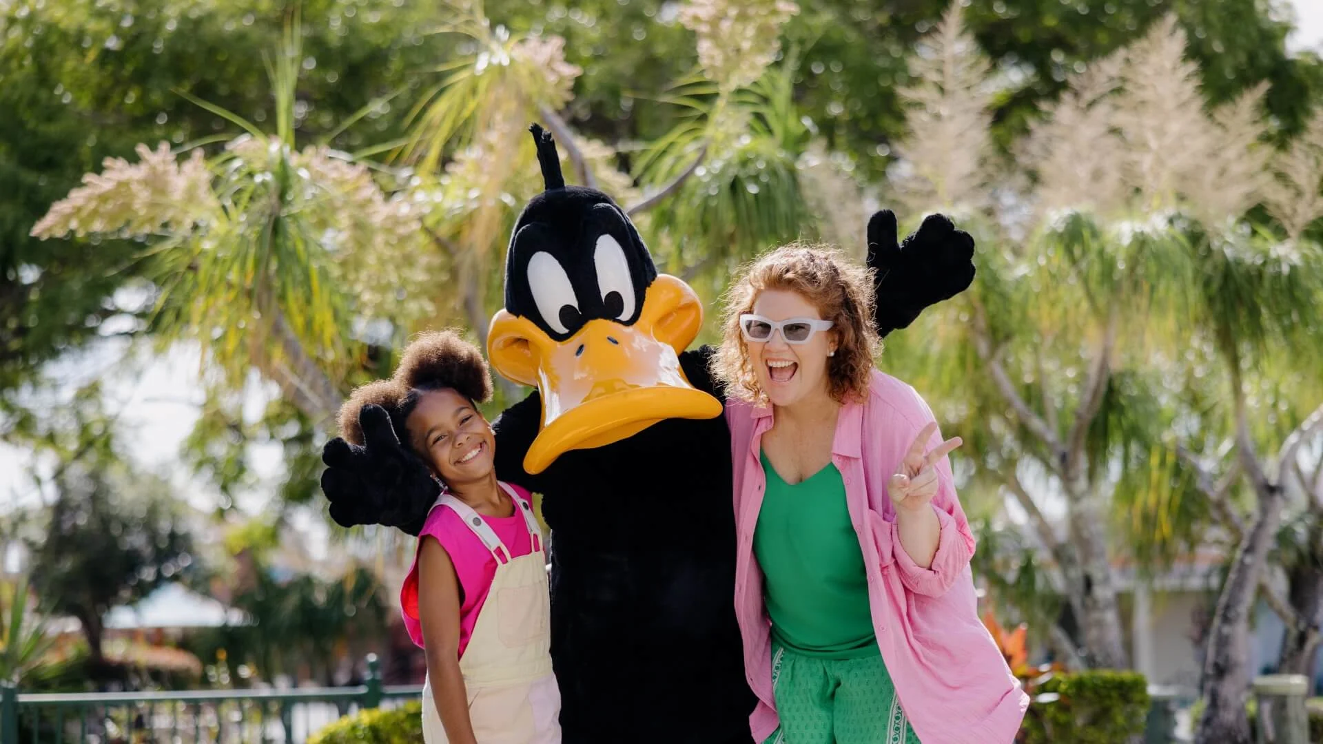 Two excited guests posing with Daffy Duck during the character meet and greets in the Kids' WB! Fun Zone at Warner Bros. Movie World. Meet and Greet