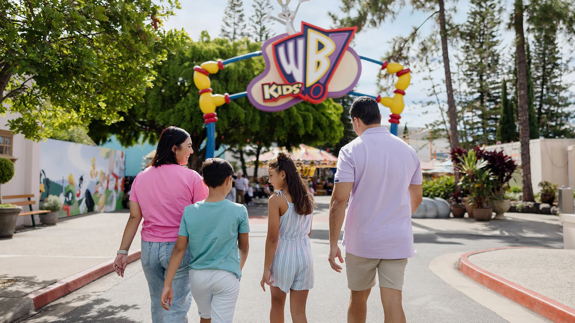 A family eagerly walking into Kids' WB! Fun Zone at Warner Bros. Movie World, ready to explore and enjoy the interactive attractions and entertainment for children