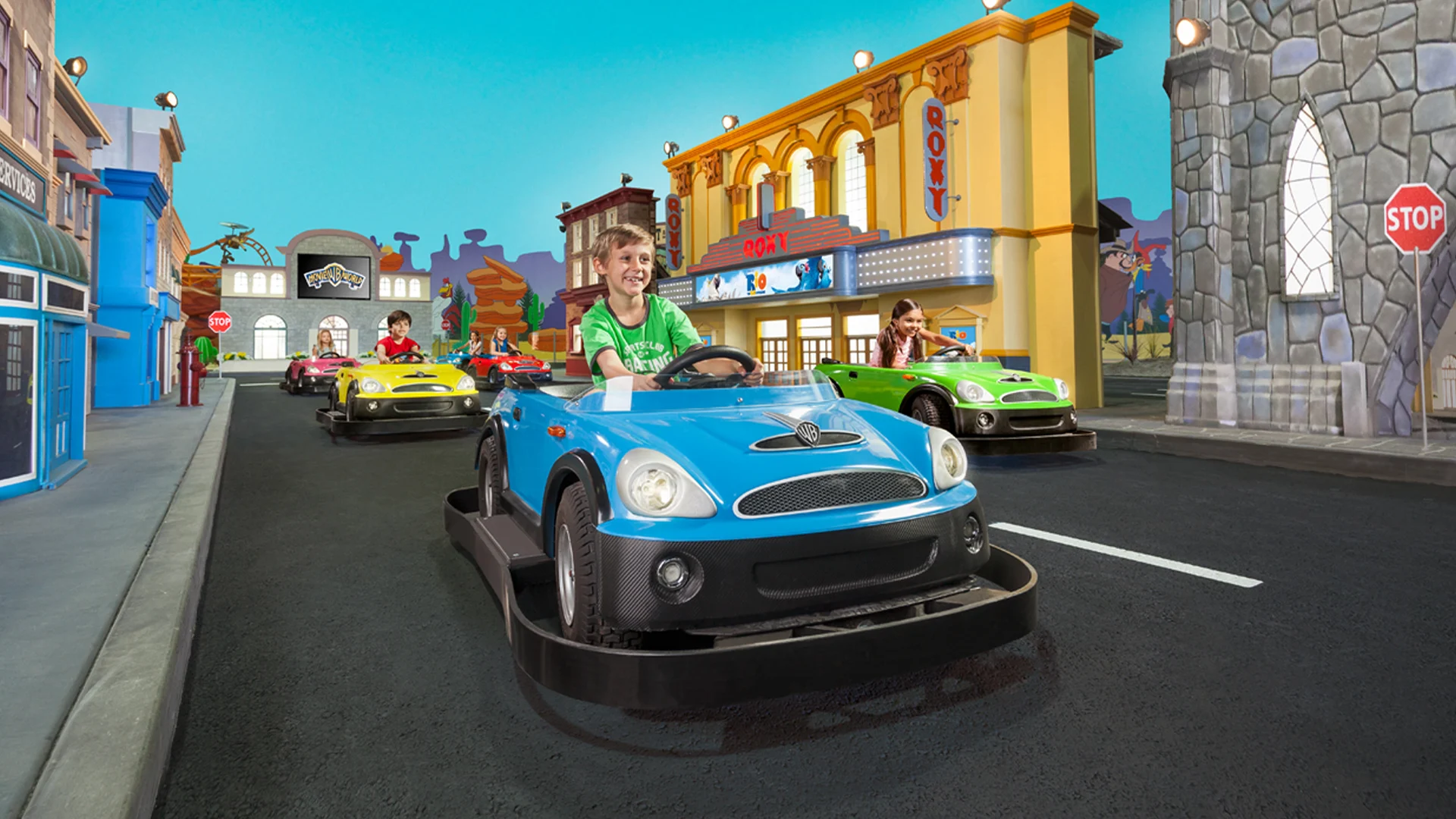 Children enjoying the Junior Driving School kids attraction at Warner Bros. Movie World, driving miniature cars around a scaled-down version of the theme park