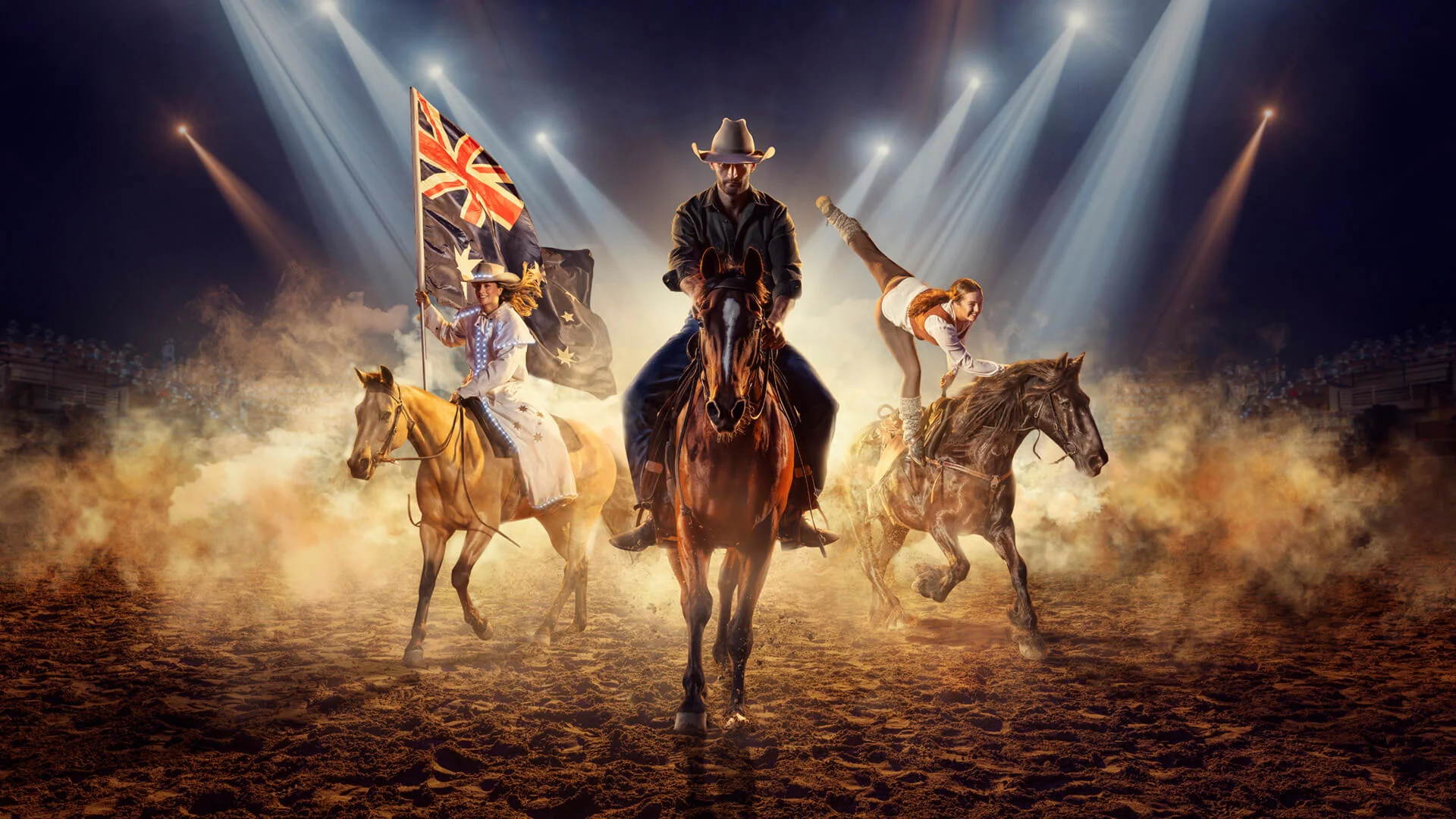 Three people on horseback perform in a rodeo arena with dramatic spotlights. One rider carries a flag, the center rider faces forward, and another does a stunt, hanging off the side of a horse. Dust and smoke fill the scene.