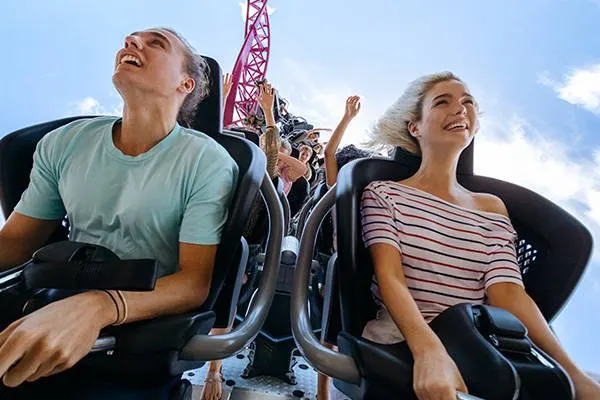 A couple enjoying a thrilling ride in the front seats of DC Rivals HyperCoaster at Warner Bros. Movie World, with excitement and exhilaration on their faces