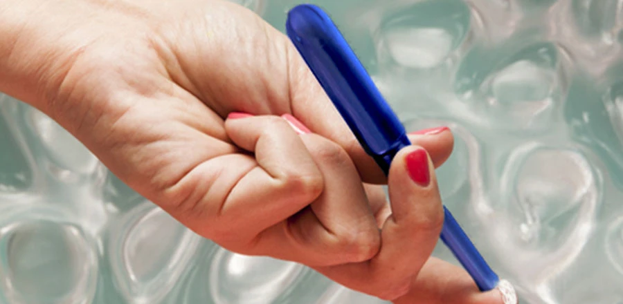 Main féminine tenant un tampon avec applicateur