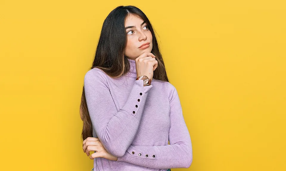 Jeune femme pensive sur le fond jaune