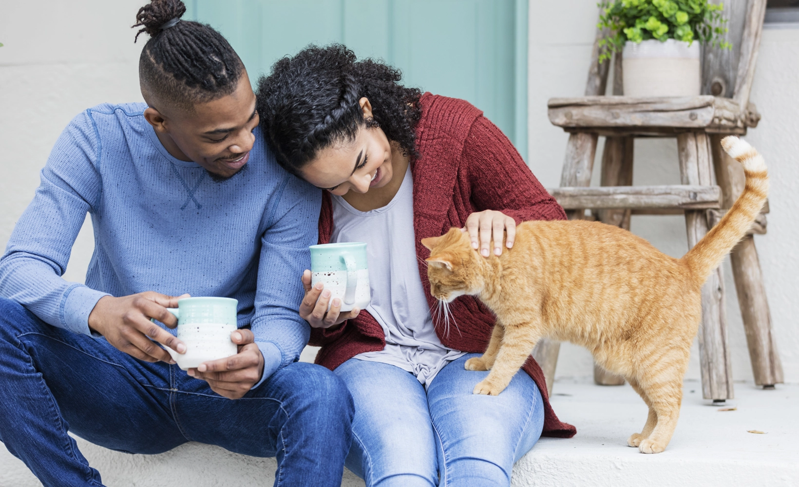 Couple on front steps with their cat