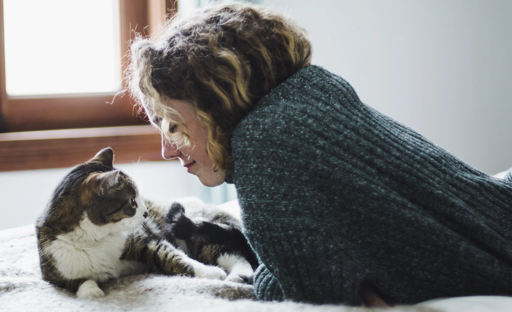 Allergy coverage - Woman on bed with cat