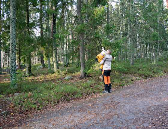 Lauri Lavanti osoittamassa puita lapselle, joka on hänen sylissään.