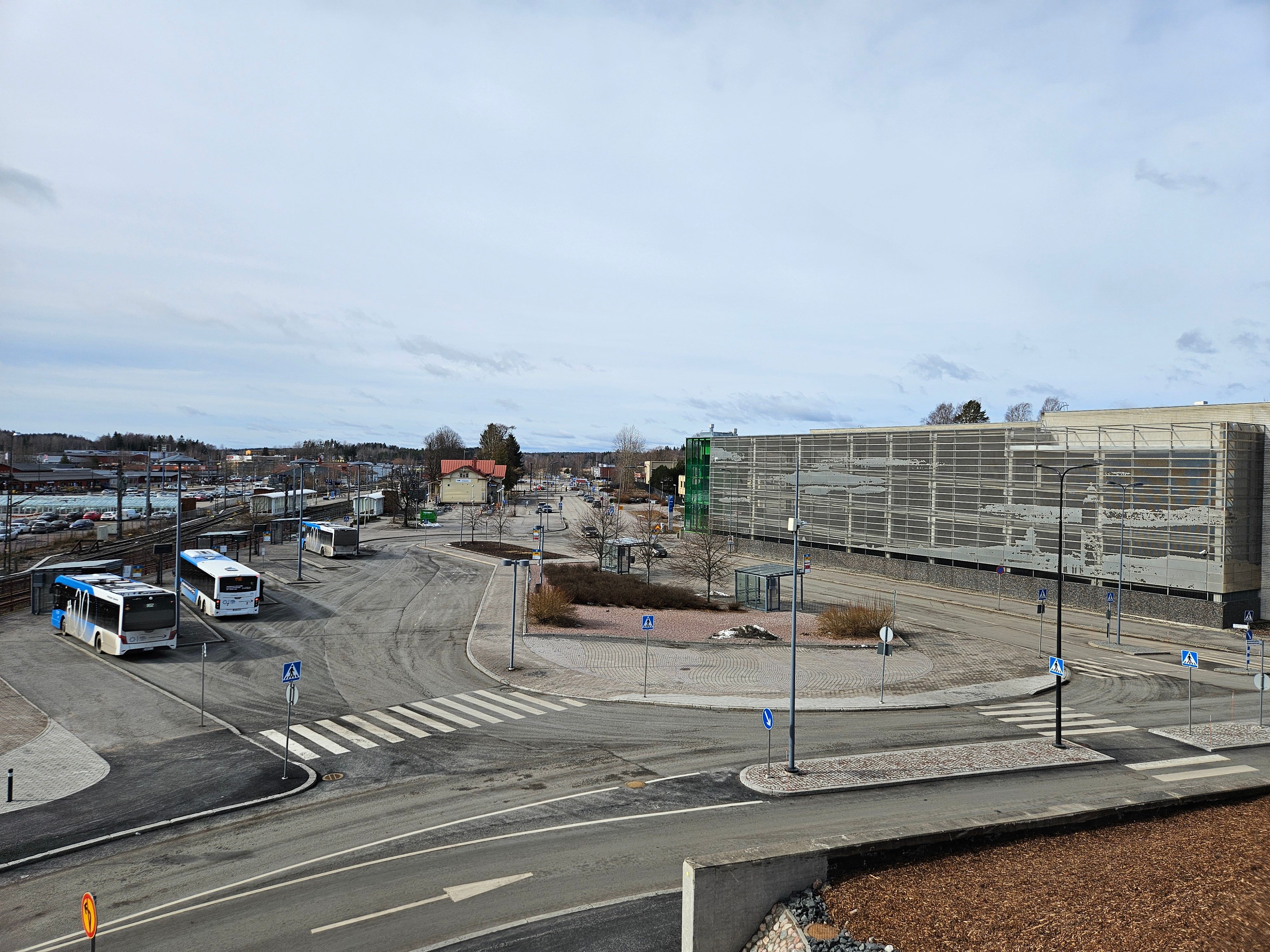 Kuva Kirkkonummen juna- ja bussiasemasta sekä vieressä näkyvästä parkkitalosta.