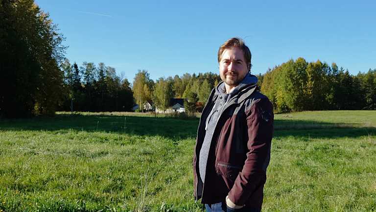Kuva Lauri Lavannista pellon edustalla. Taaempana taustalla on metsää.