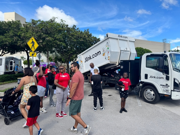 A crowd gathers around the Junk.com same-day junk removal truck at the Pembroke Pines, FL Touch-a-Truck Vehicle Expo.