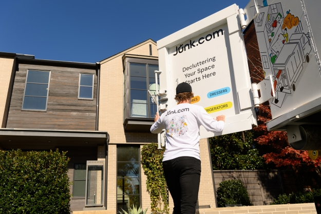 A Junk.com team member closes a junk truck after clearing clutter from a home.