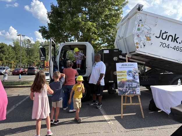 Charlotte families line up to explore the Junk.com junk truck at a local Touch-a-Truck event.