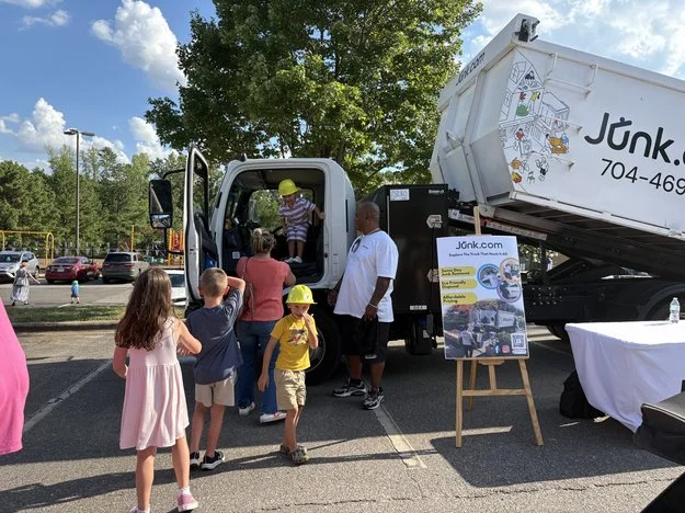 Charlotte families line up to explore the Junk.com junk truck at a local Touch-a-Truck event.