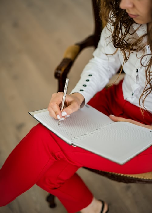 Woman writing down schedule on a note book