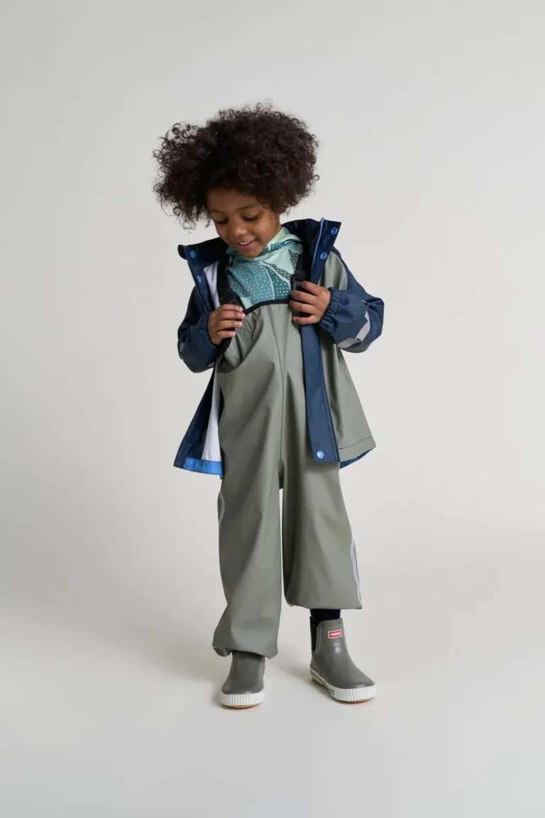 kid-wearing-reima-waterproof-rain-pants-and-rain-coat-to-play-outside