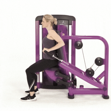 Woman in workout clothes performing triceps pushdown exercise using strength machine