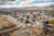 An aerial view shows a new housing development with construction happening in the foreground, and mountains in the background.