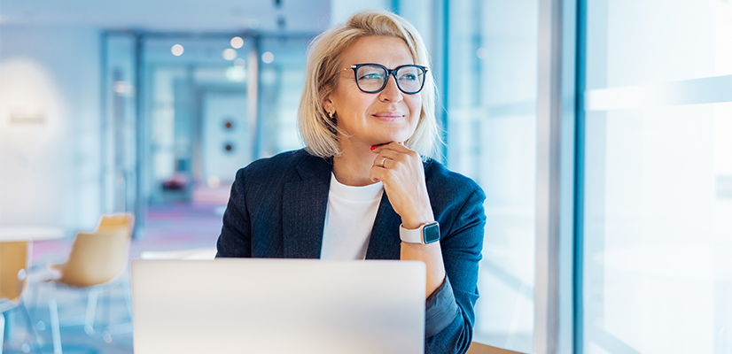 Businesswoman on computer looking out window 