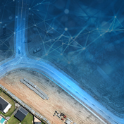 An aerial image of a construction site and road is overlaid with a blue, web-like digital network pattern.