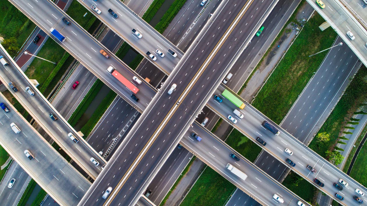 An aerial view of a complex highway interchange with multiple intersecting roads and cars.