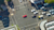 An aerial view of a busy city intersection with cars and pedestrians moving in different directions.