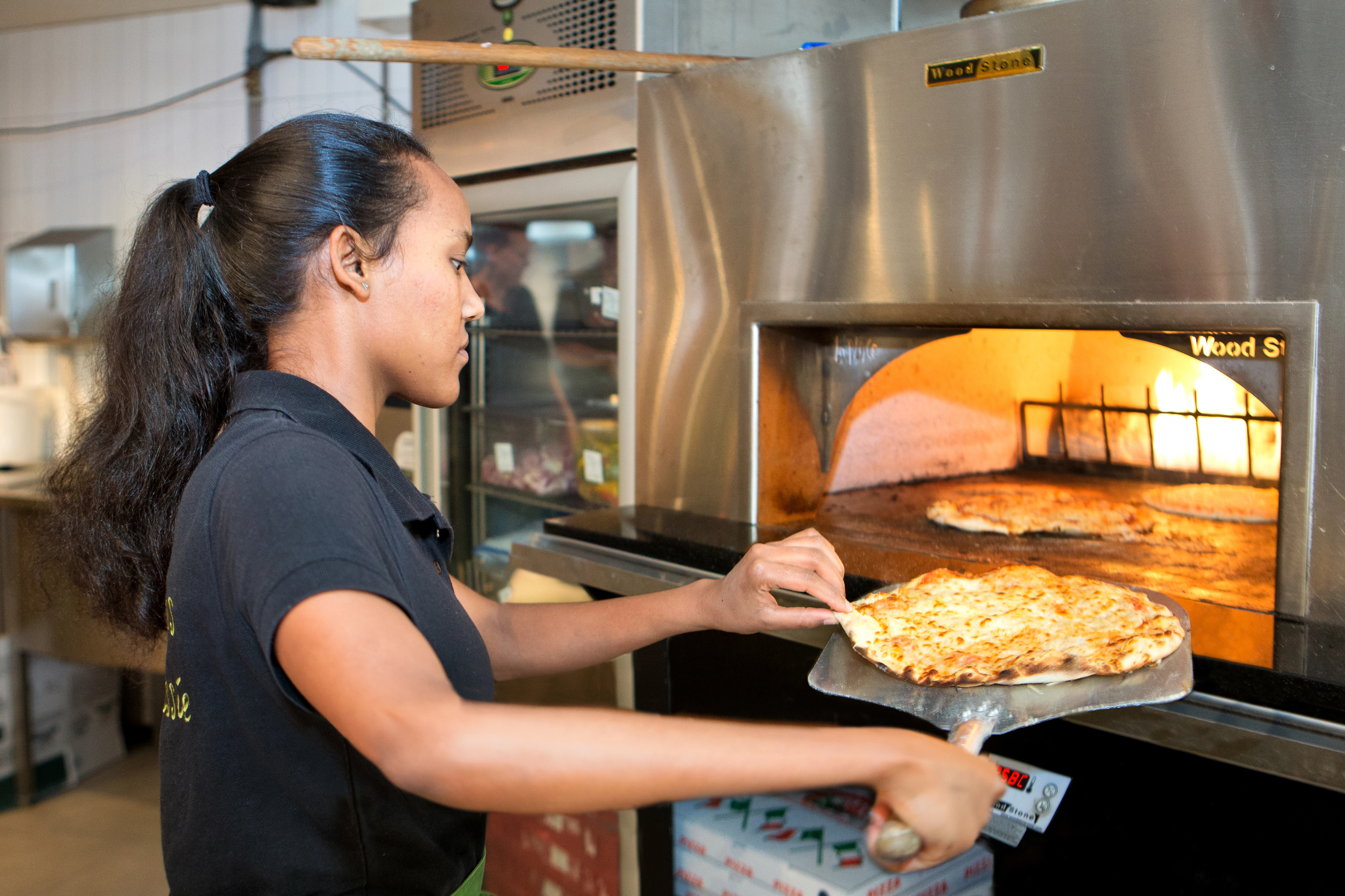 Vrouw aan het werk als pizzabakker