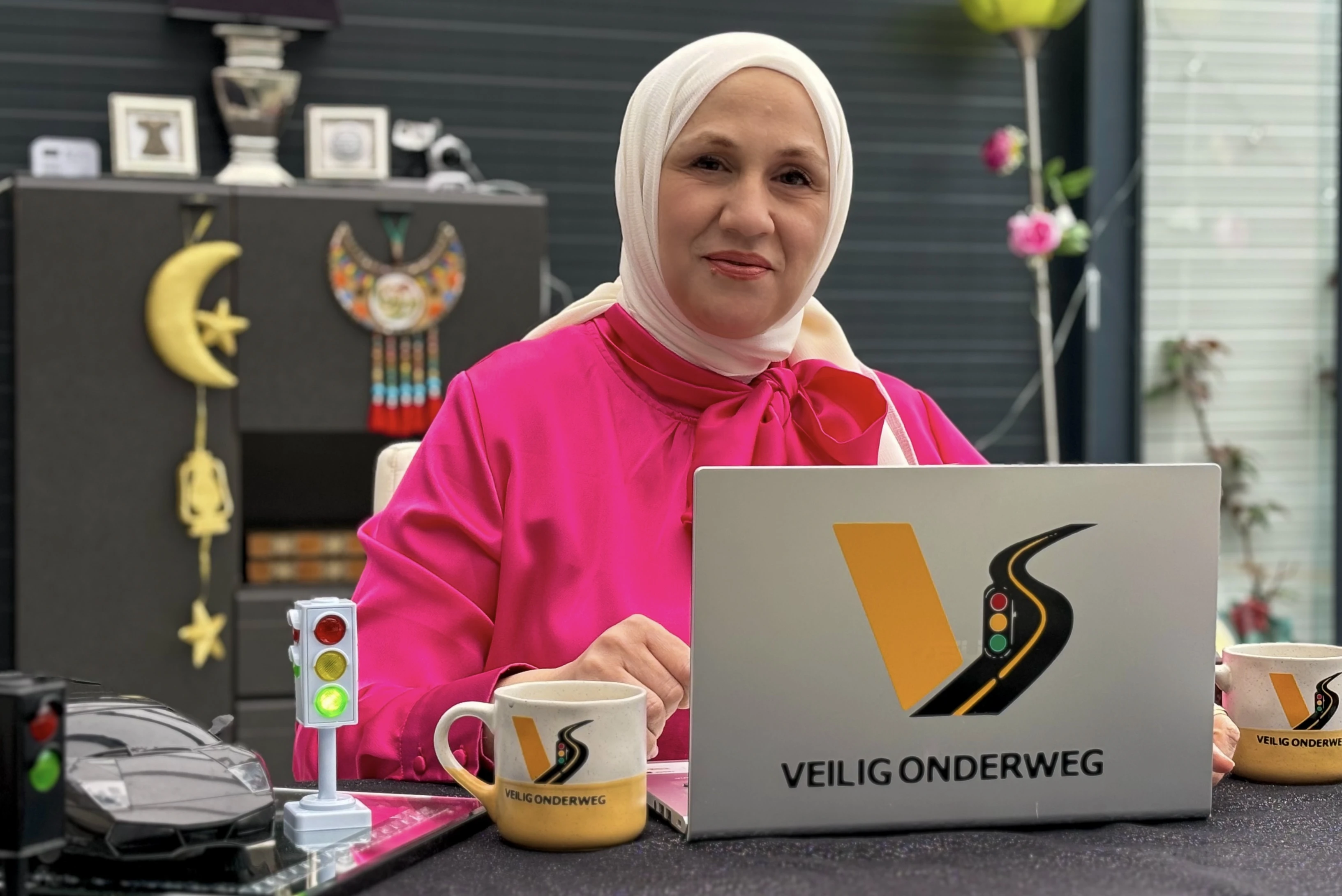 Loubna Bazarbashi gives theory traffic lessons with her company 'Veilig Onderweg'. Loubna sits behind her laptop.