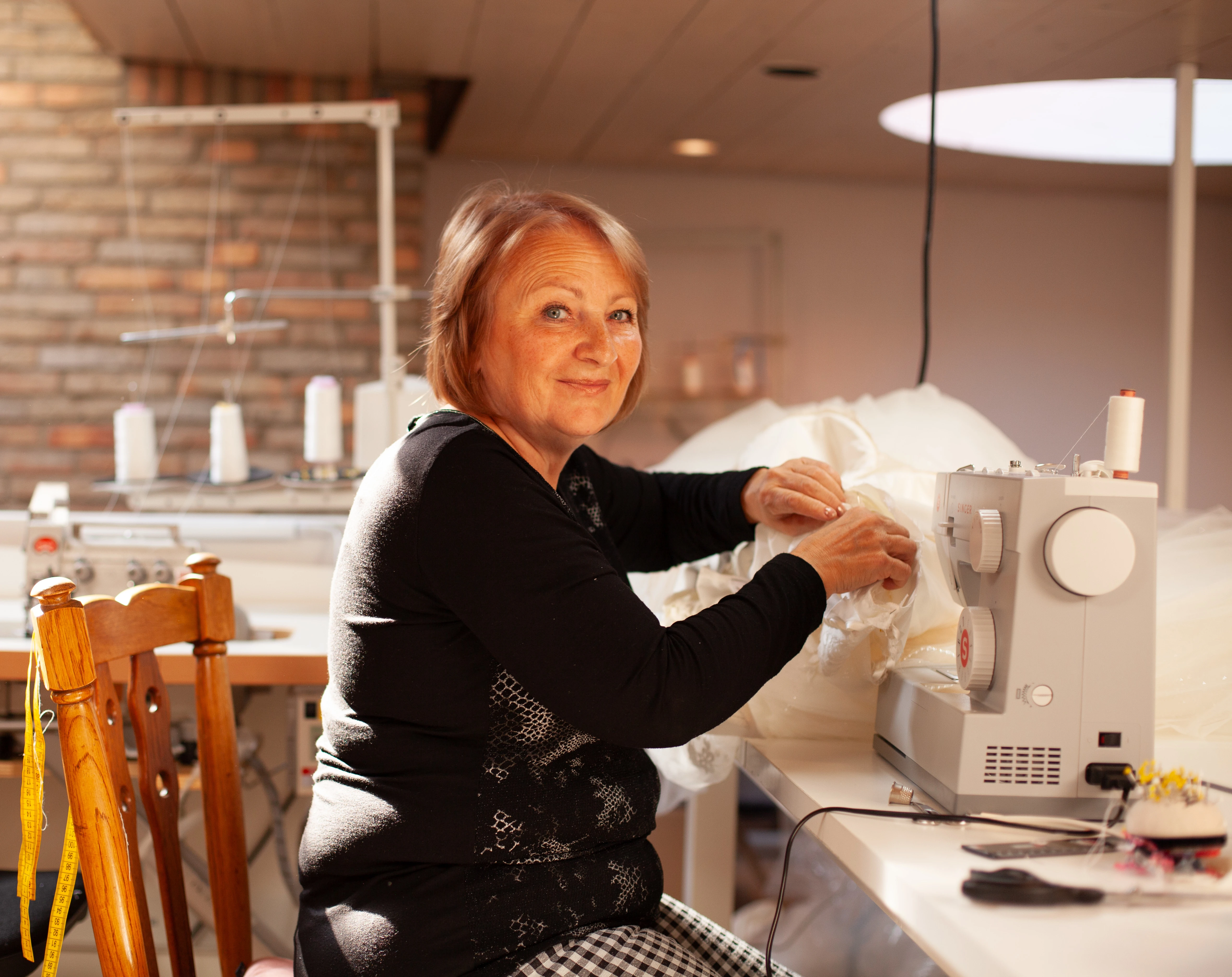 A Ukrainian woman is at work behind the sewing machine