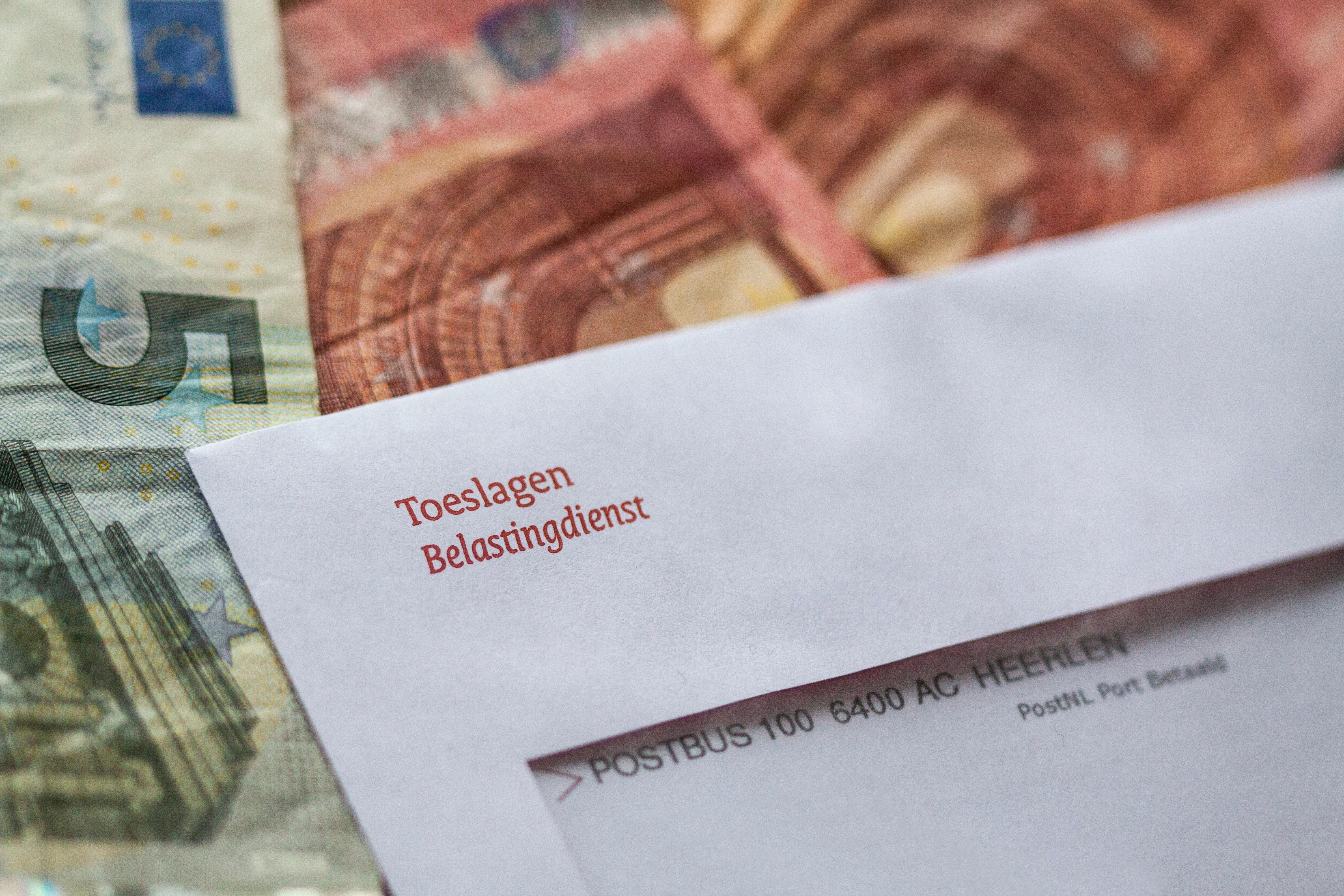 Een envelop van de Belastingdienst met informatie over Toeslagen. De envelop ligt op briefgeld.