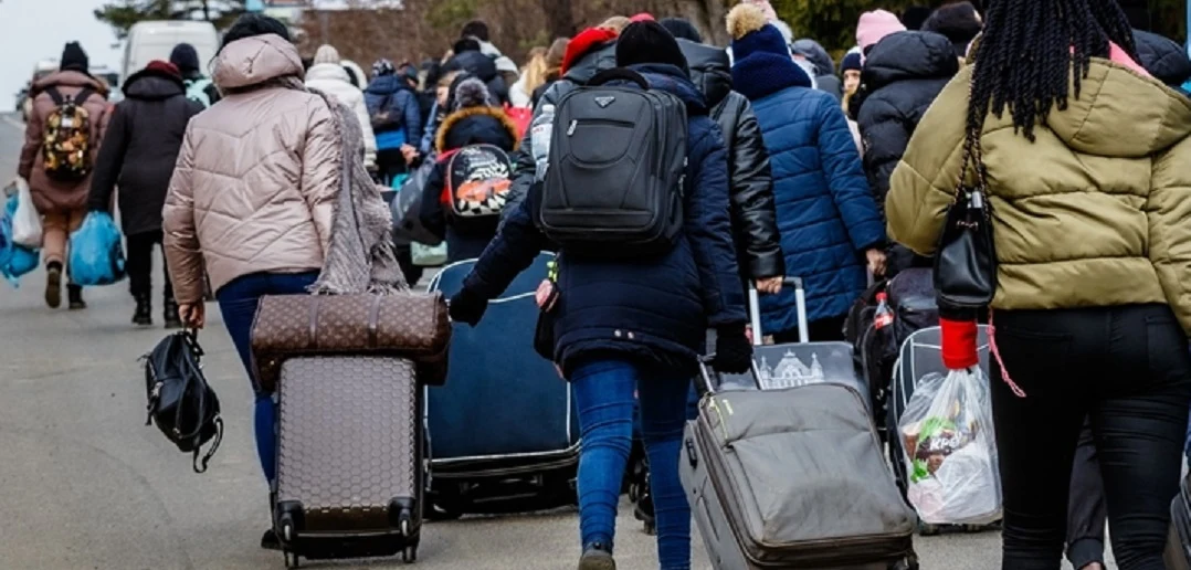 Mensen verlaten Nederland met grote rolkoffers