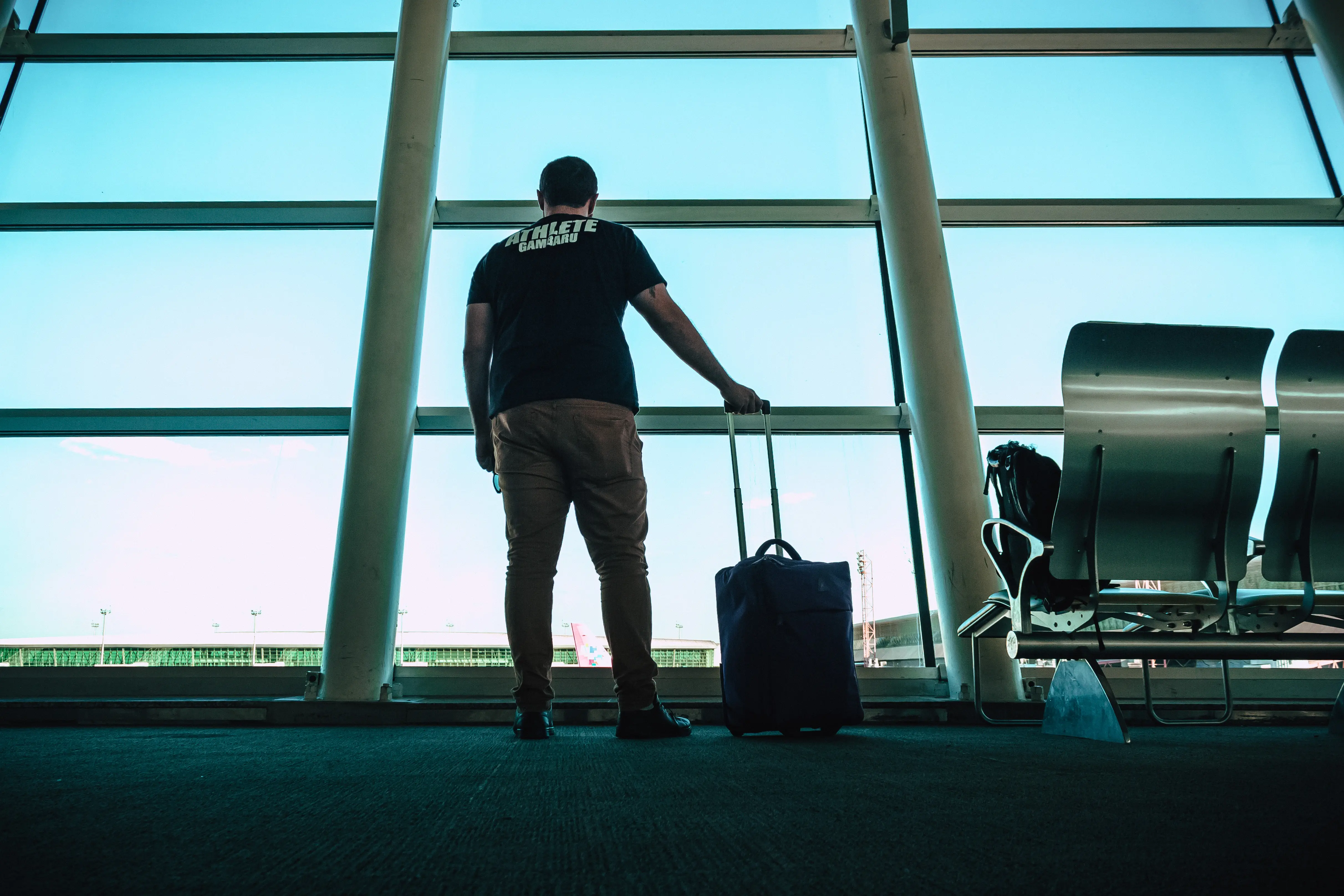 Man waits in front of gate at an airport