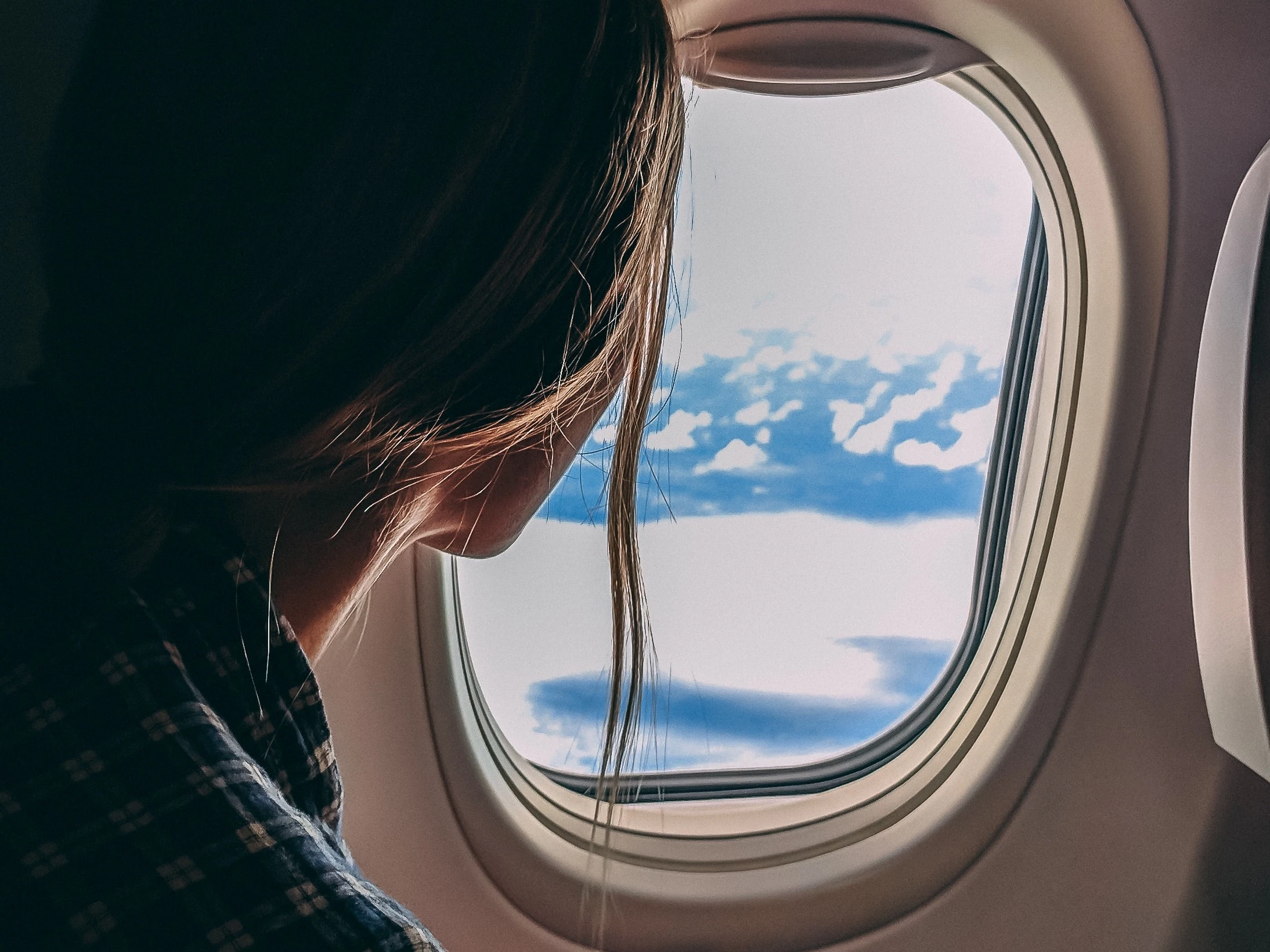 Woman looks out of plane window