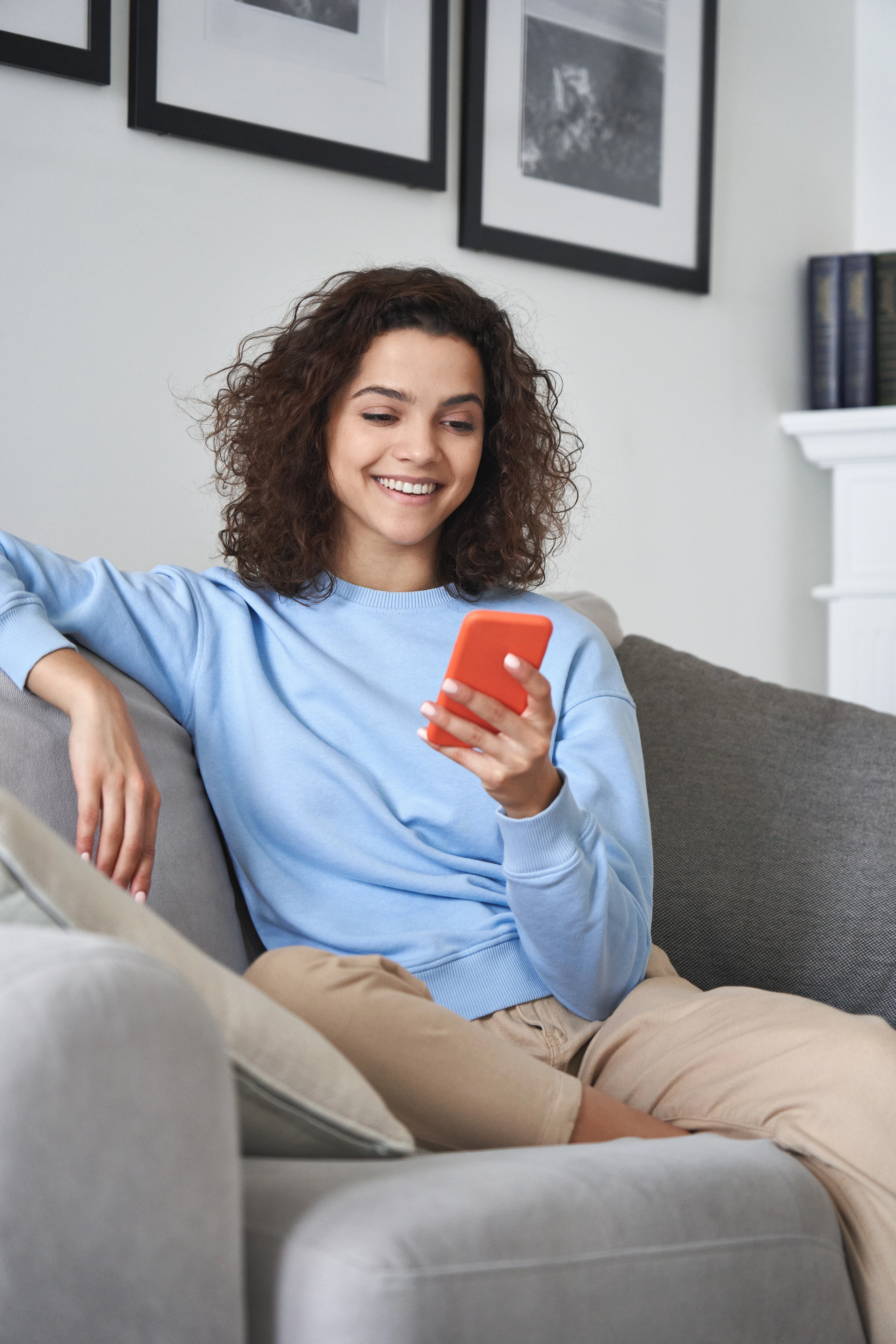 A man videotapes via his phone and waves in the direction of his phone.